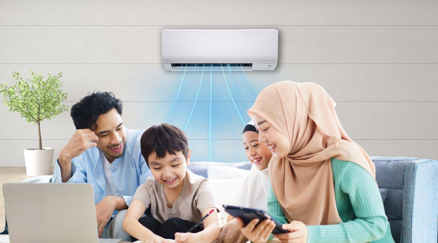 Sebuah keluarga menggunakan telefon pintar di bawah unit aircond Daikin di ruang tamu